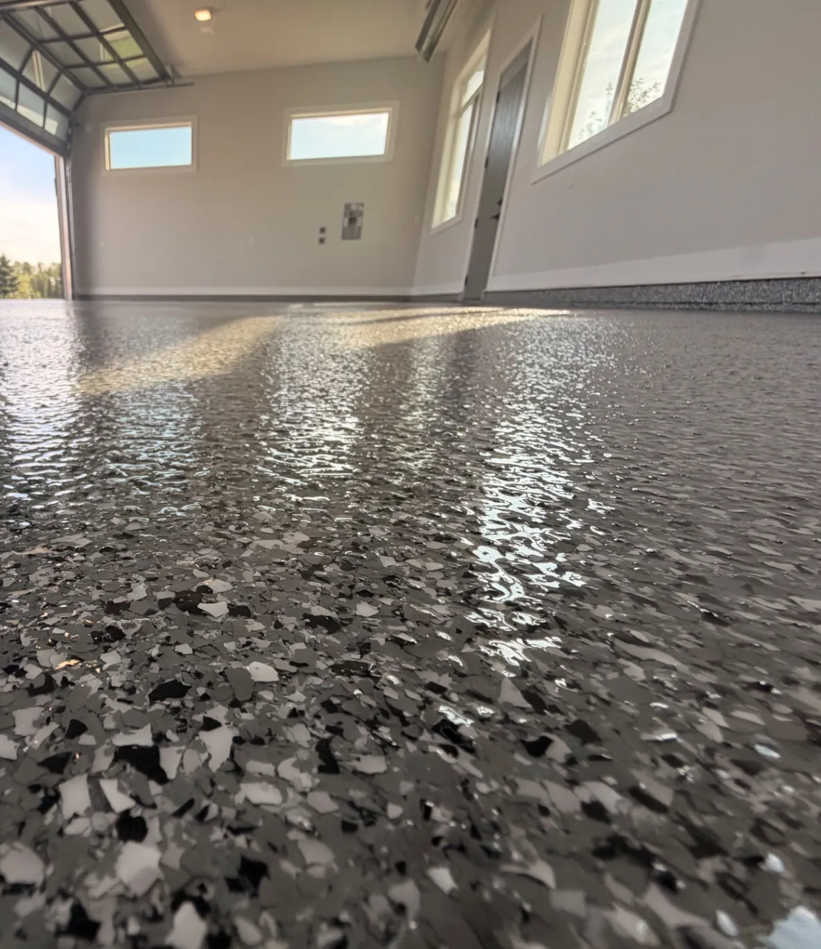 Completed charcoal flake epoxy garage floor with dramatic overhead lighting
