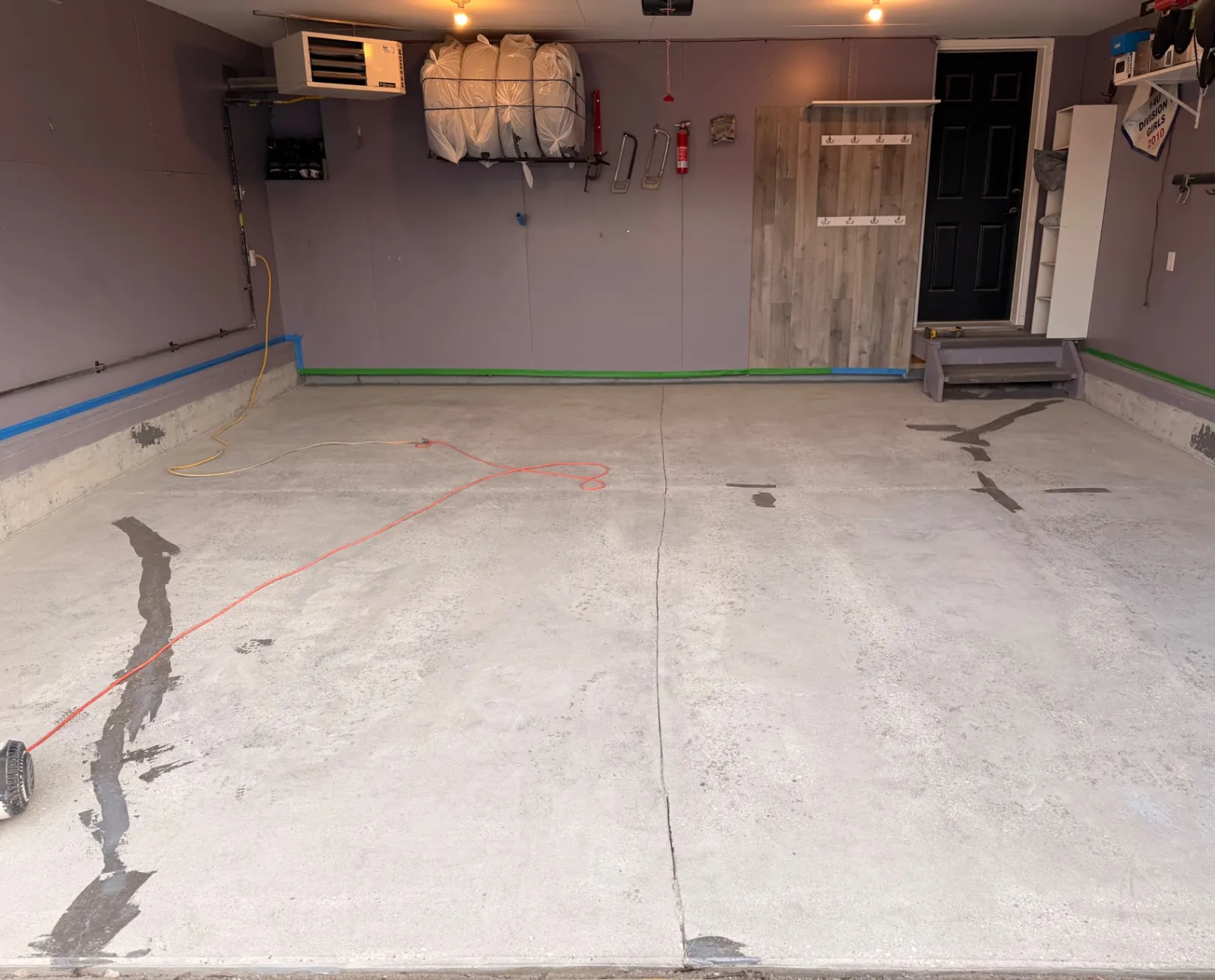 Bare, cracked concrete garage floor before coating